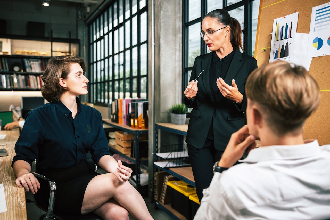 Three colleagues engage in a vibrant business meeting in a modern office setting.